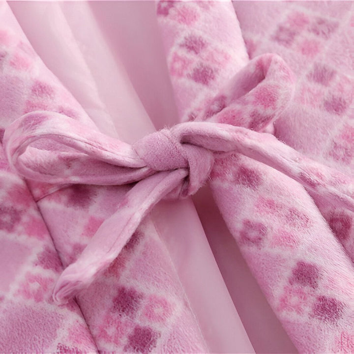Détail d'un kimono rose à motifs floraux, noué par une ceinture assortie. Vêtement traditionnel japonais, idéal pour un style élégant et confortable. Découvrez notre collection de kimonos.