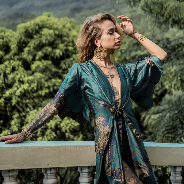 Femme portant un kimono turquoise à motifs. Kimono de notre collection. Vue extérieure, style bohème, bijoux dorés. Vêtements pour femmes.