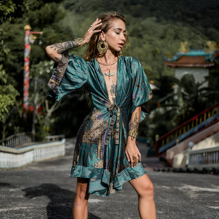 Femme portant un kimono court en soie turquoise à motifs, bijoux dorés, tatouages. Vêtements kimono élégants.