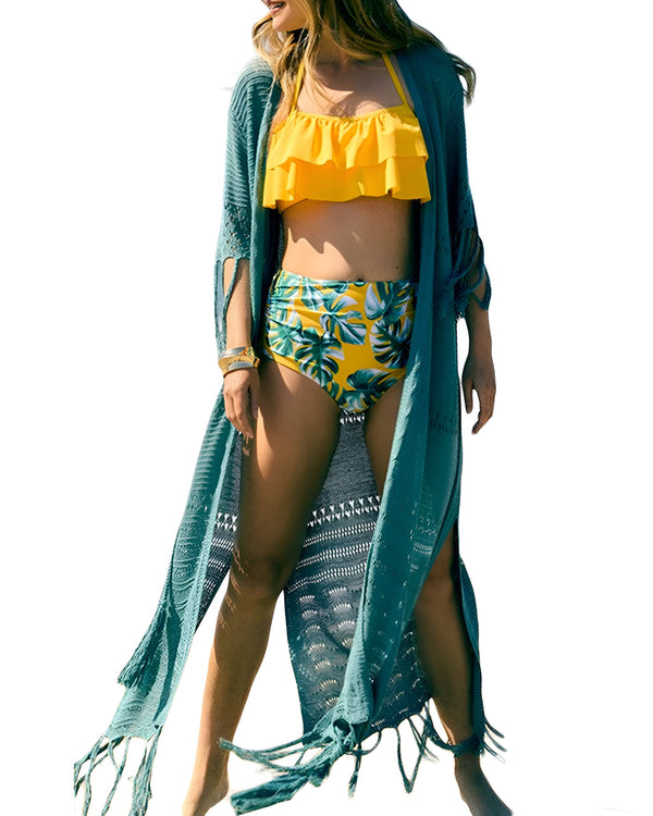 Femme portant un kimono turquoise long ajouré avec des franges, par-dessus un maillot de bain jaune et imprimé feuilles tropicales. Kimonos pour femmes disponibles à l'achat en ligne.