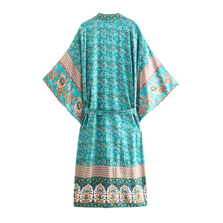 Kimono turquoise fleuri avec ceinture. Vêtement ample et léger, idéal pour la maison ou les sorties estivales. Motifs floraux variés pour un style unique.