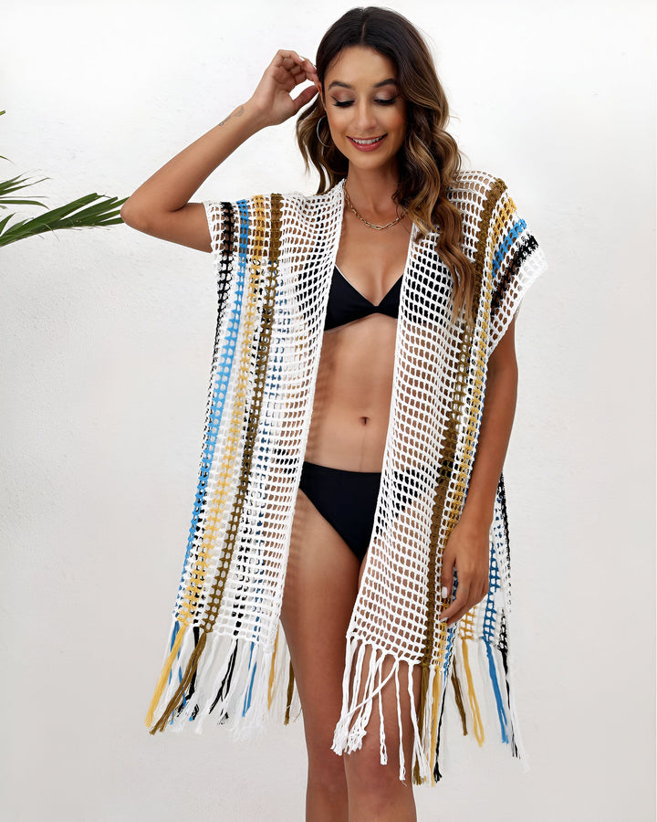 Femme souriante portant un kimono ajouré multicolore sur un maillot de bain noir. Kimono de plage tendance avec franges. Collection de kimonos pour femmes.