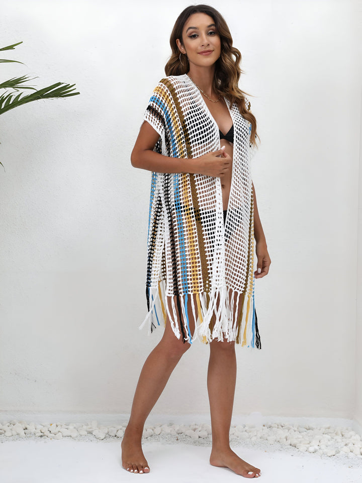 Femme portant un kimono de plage en crochet coloré avec des franges. Vêtement léger et tendance pour l'été. Découvrez notre collection de kimonos.