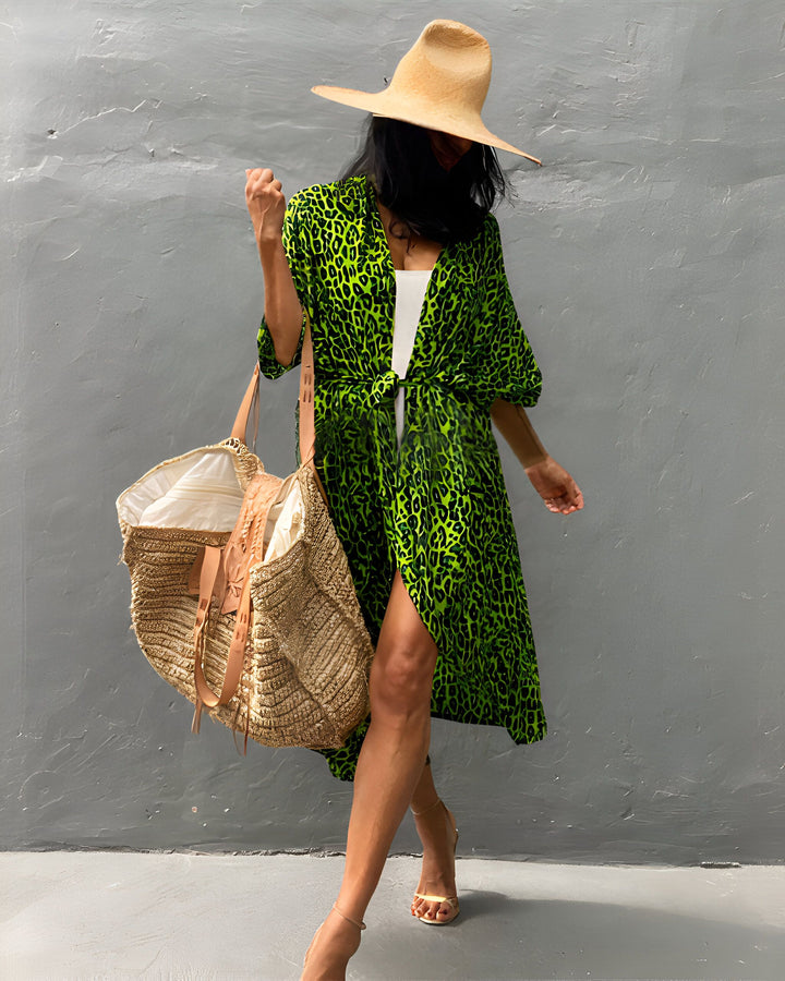 Femme portant un kimono vert à imprimé léopard, chapeau de paille et sac de plage. Style décontracté chic. Collection kimonos, boutique en ligne.