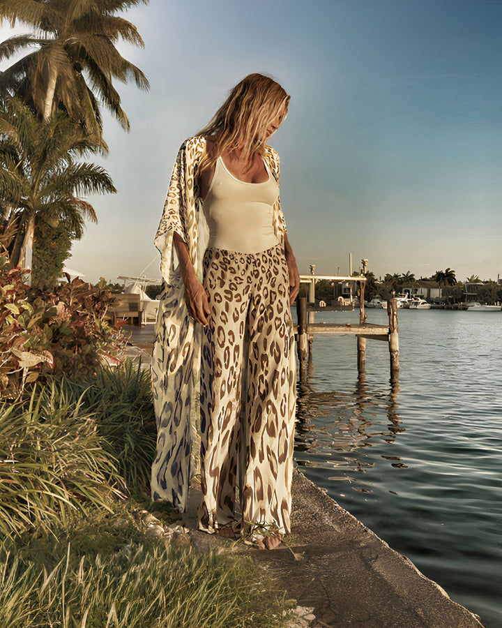 Femme portant un kimono imprimé léopard et un pantalon assorti, au bord de l'eau. Collection de kimonos.