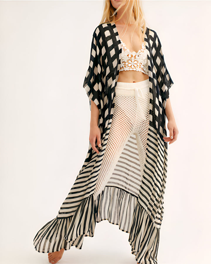 Femme portant un kimono long à rayures noires et blanches, avec un haut en dentelle et un pantalon crocheté blancs. Collection de kimonos élégants.