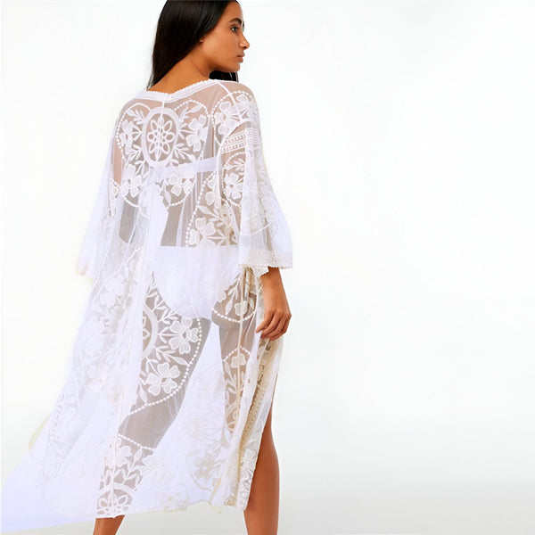 Femme portant un kimono long blanc en dentelle florale. Vêtements de plage, mode estivale, collection de kimonos.