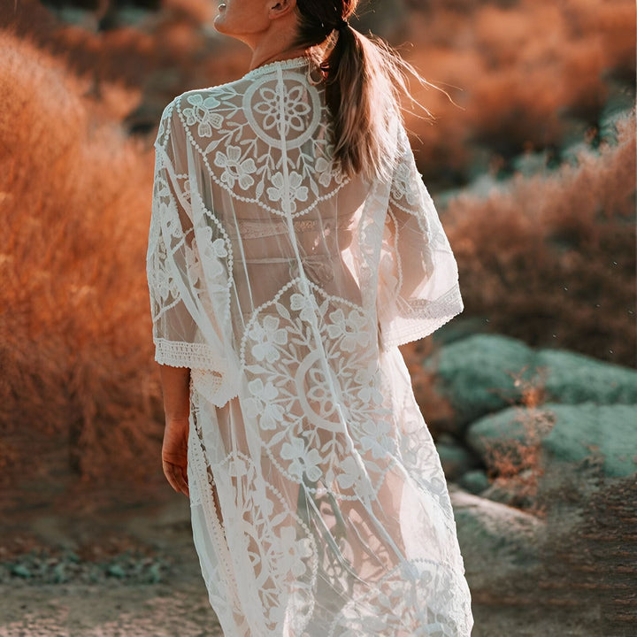 Femme portant un kimono blanc en dentelle, vue de dos. Élégance bohème, idéal comme vêtement d'extérieur ou de plage. Découvrez notre collection de kimonos uniques.