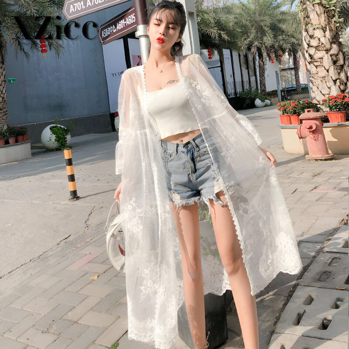 Femme portant un kimono blanc en dentelle transparent, short en jean, et top court. Kimonos élégants et de haute qualité disponibles à l'achat en ligne.