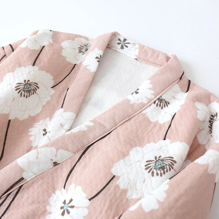 Détail d'un kimono rose à motifs floraux blancs. Vêtement japonais traditionnel, idéal pour un look élégant et confortable. Découvrez notre collection de kimonos uniques!