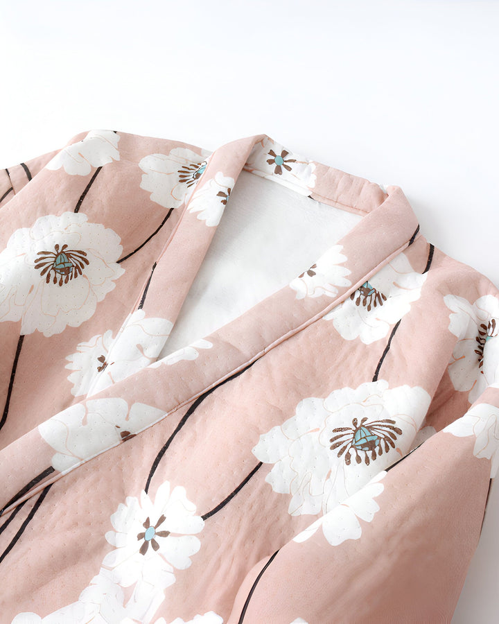 Détail d'un kimono rose à motifs floraux blancs. Vêtement traditionnel japonais. Idéal pour la détente à la maison. Notre collection de kimonos pour femme.