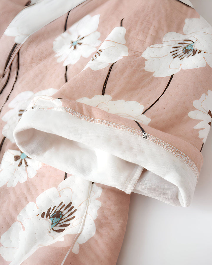 Détail d'un kimono rose à motifs floraux blancs. Idéal pour un look japonais élégant et confortable. Découvrez notre collection de kimonos uniques.