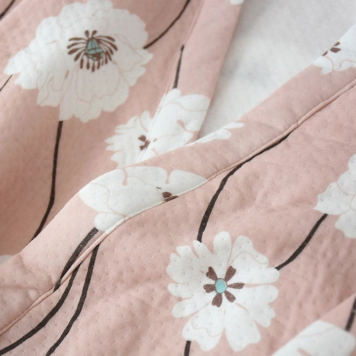 Détail d'un kimono rose avec motifs floraux blancs. Tissu doux et élégant, parfait pour un style japonais authentique. Découvrez notre collection de kimonos uniques.