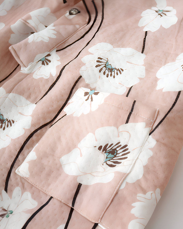 Détail d'un kimono fleuri rose poudré avec une poche. Motifs floraux blancs et tiges noires. Kimono élégant et confortable de notre collection.