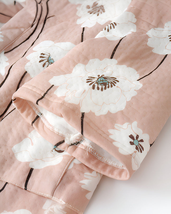 Détail d'un kimono rose pâle à motif floral blanc. Vêtements japonais traditionnels disponibles à l'achat.