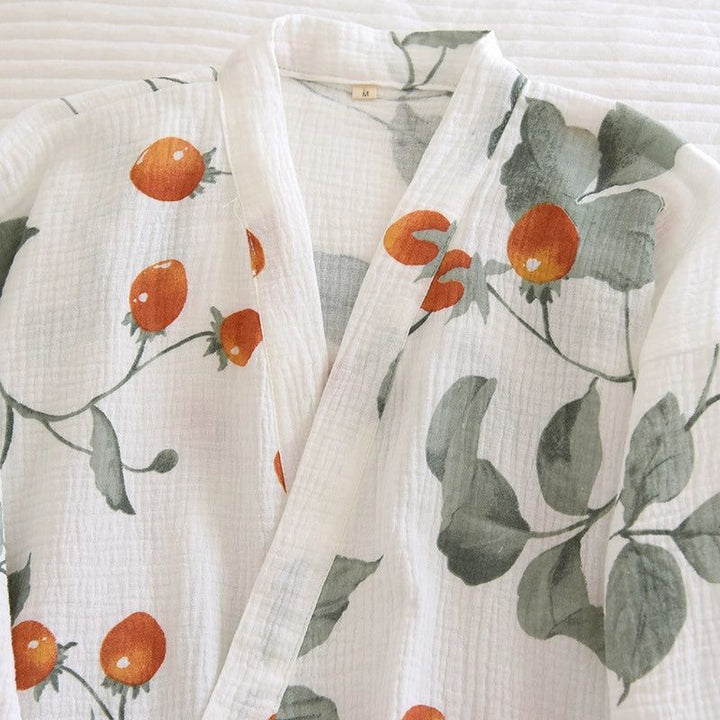 Kimono blanc à motifs de fraises, vêtement japonais traditionnel. Détails du tissu texturé et du design imprimé. Idéal pour se détendre à la maison avec style. Découvrez notre collection de kimonos uniques.