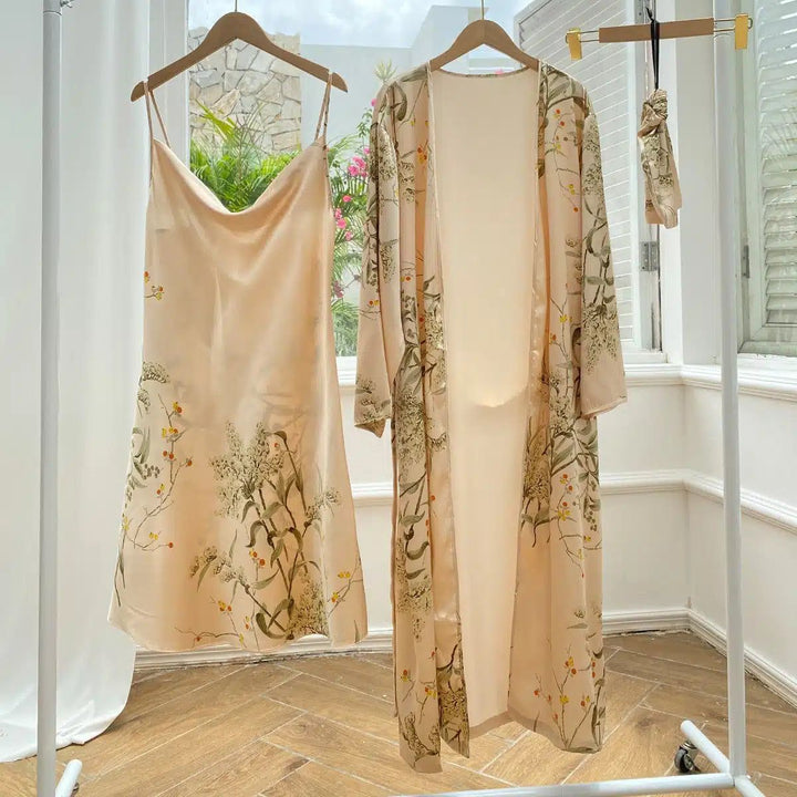 Ensemble kimono fleuri pêche. Comprend une robe nuisette à fines bretelles et un kimono long assorti, suspendus sur un portant. Idéal pour un look élégant et confortable. Découvrez notre collection de kimonos en ligne !