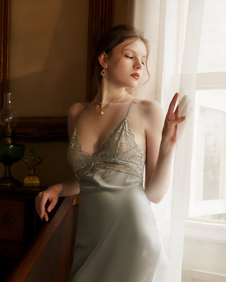 Femme élégante en nuisette satinée à dentelle, regardant par la fenêtre. Vêtements de nuit, kimono et lingerie disponibles.
