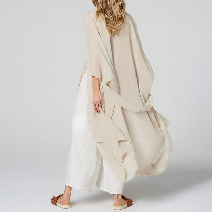 Femme portant un kimono beige élégant avec un pantalon blanc ample. Vêtements d'intérieur confortables et décontractés. Mode kimono contemporaine.