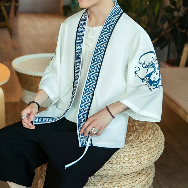 Homme portant un kimono blanc avec motifs bleus. Vêtements traditionnels japonais. Boutique de kimonos en ligne. Style asiatique tendance.