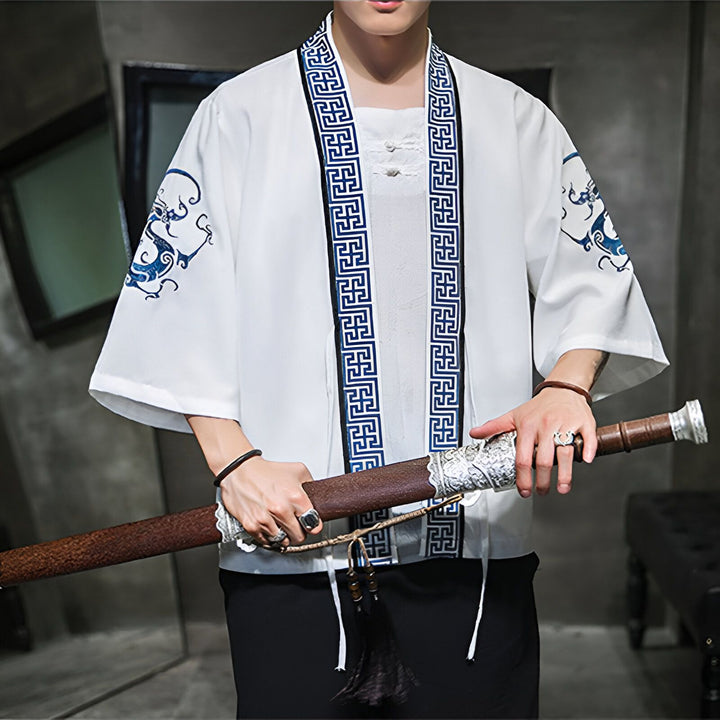 Homme portant un kimono blanc avec motifs bleus, tenant un katana. Kimono japonais traditionnel et moderne à vendre.