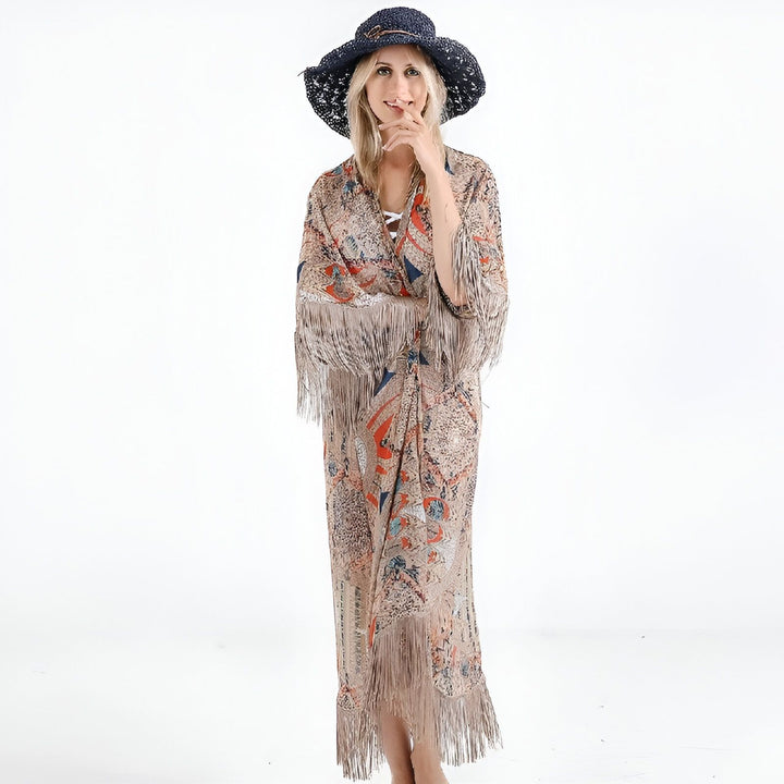 Femme souriante portant un kimono long à motifs avec franges et un chapeau bleu. Vêtements de plage chics. Collection de kimonos.