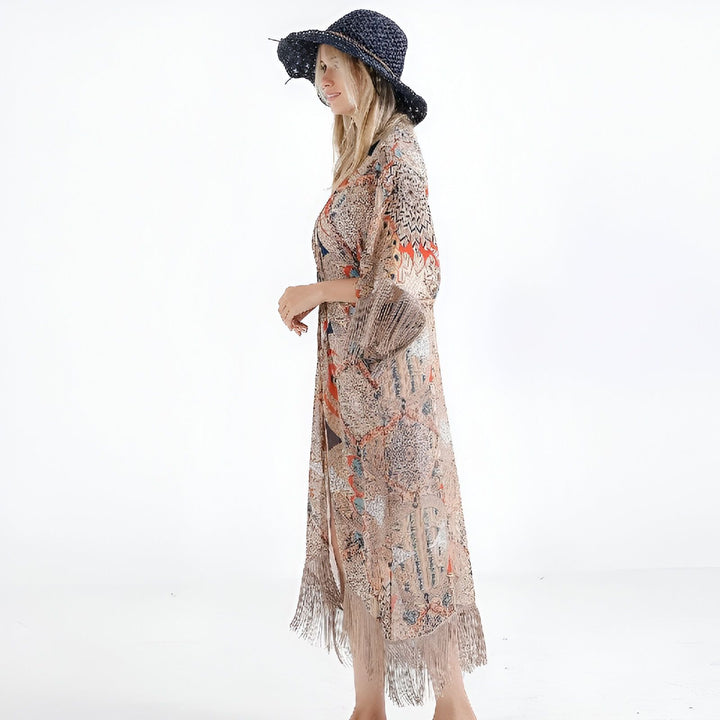 Femme portant un kimono long à motifs avec des franges, et un chapeau. Découvrez notre collection de kimonos uniques.