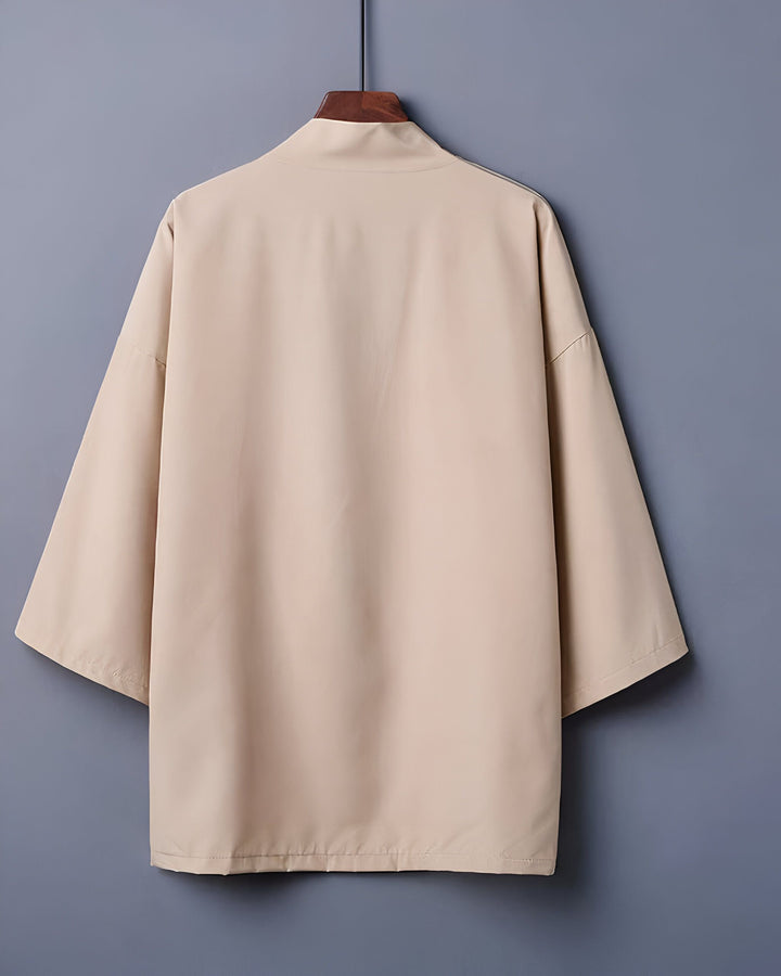 Kimono beige suspendu sur un cintre. Vêtement japonais traditionnel, coupe ample, manches larges. Découvrez notre collection de kimonos !