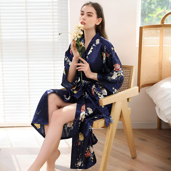 Femme portant un kimono bleu marine à motifs floraux. Élégance et confort pour la maison. Kimonos de qualité supérieure disponibles à l'achat. Idéal pour se détendre avec style.