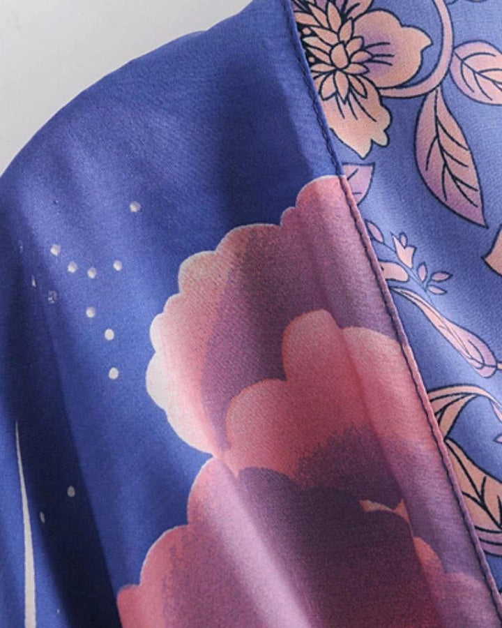 Détail d'un kimono bleu avec motifs floraux roses et violets. Texture douce et élégante, idéale pour un style japonais raffiné. Kimonos disponibles à l'achat.