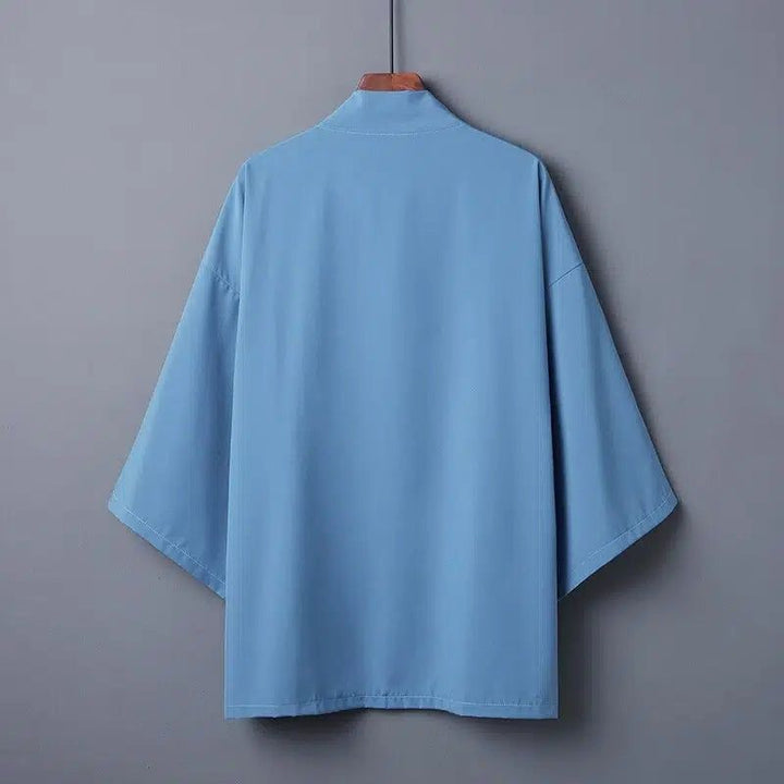 Kimono bleu clair pour homme sur cintre. Vêtement japonais traditionnel avec manches larges. Idéal pour un style décontracté et élégant. Découvrez notre collection de kimonos uniques.