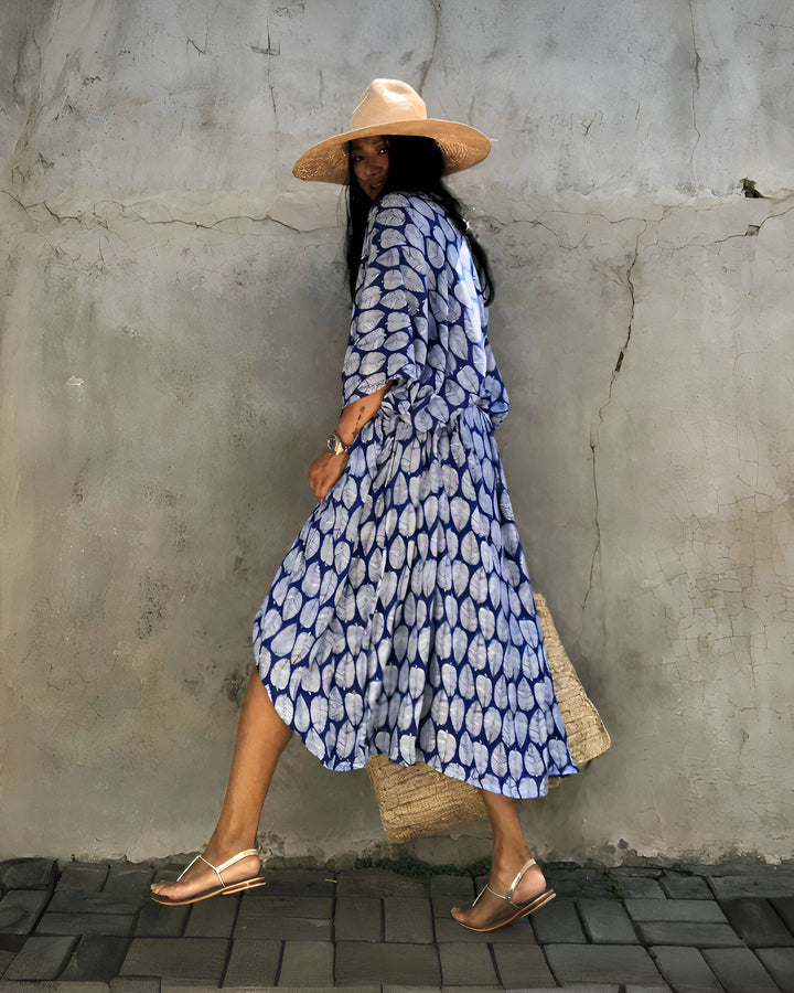 Femme portant un kimono bleu à motifs de feuilles, chapeau de paille. Vente de kimonos en ligne.
