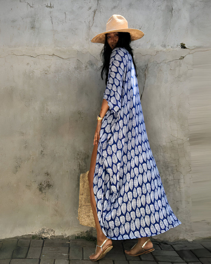 Femme portant un kimono bleu à motifs, un chapeau de paille et des sandales. Sac en paille. Vente de kimonos pour femmes.