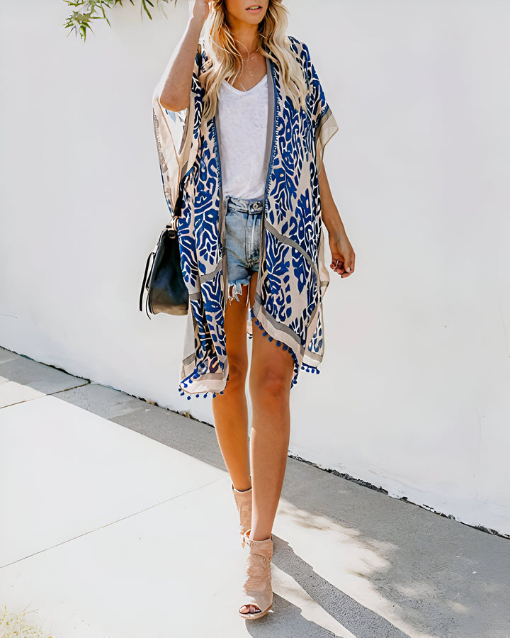Femme portant un kimono bleu et beige à motifs, short en jean, et talons hauts. Vente de kimonos en ligne. Style bohème chic.