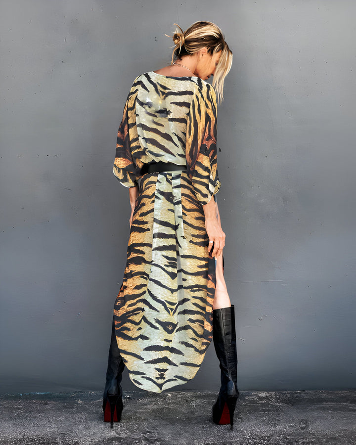 Femme portant un kimono long à motif tigre, bottes noires à talons. Vêtement fluide et tendance, idéal pour un look audacieux. Découvrez notre collection de kimonos uniques.
