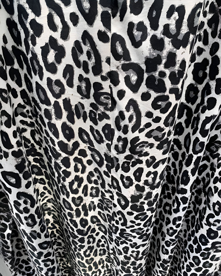 Kimono à imprimé léopard noir et blanc. Tissu plissé avec un motif animalier audacieux. Parfait pour un style unique et tendance. Découvrez notre collection de kimonos.
