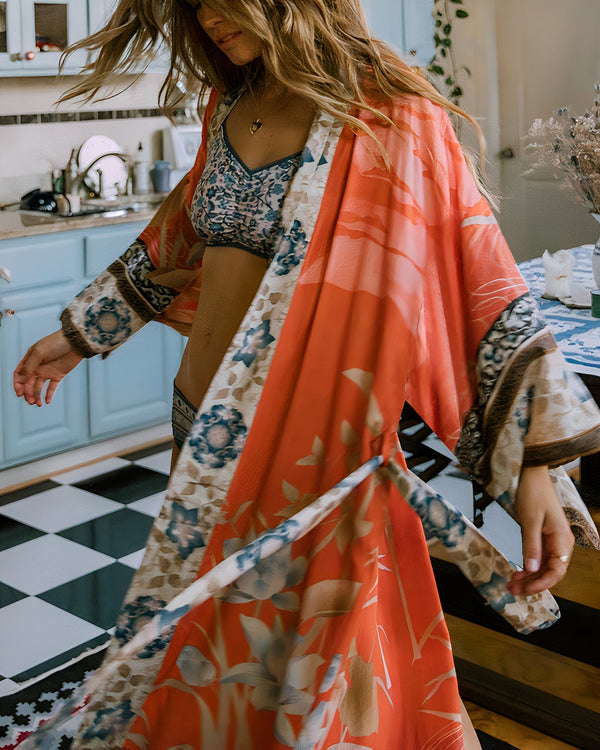 Femme portant un kimono orange à motifs floraux dans une cuisine vintage. Vêtements de détente élégants. Collection de kimonos pour femmes.