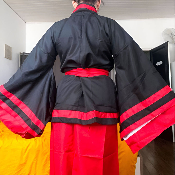 Dos d'une personne portant un kimono noir et rouge. Kimono traditionnel japonais, disponible à l'achat. Vêtements japonais.