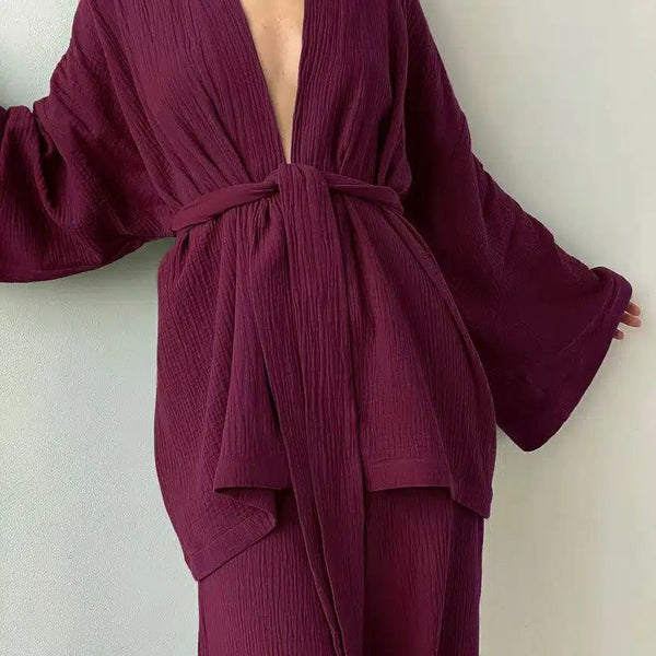 Kimono bordeaux en tissu texturé, noué à la taille. Vêtement ample avec manches évasées. Idéal pour se détendre avec style. Découvrez notre collection de kimonos uniques.