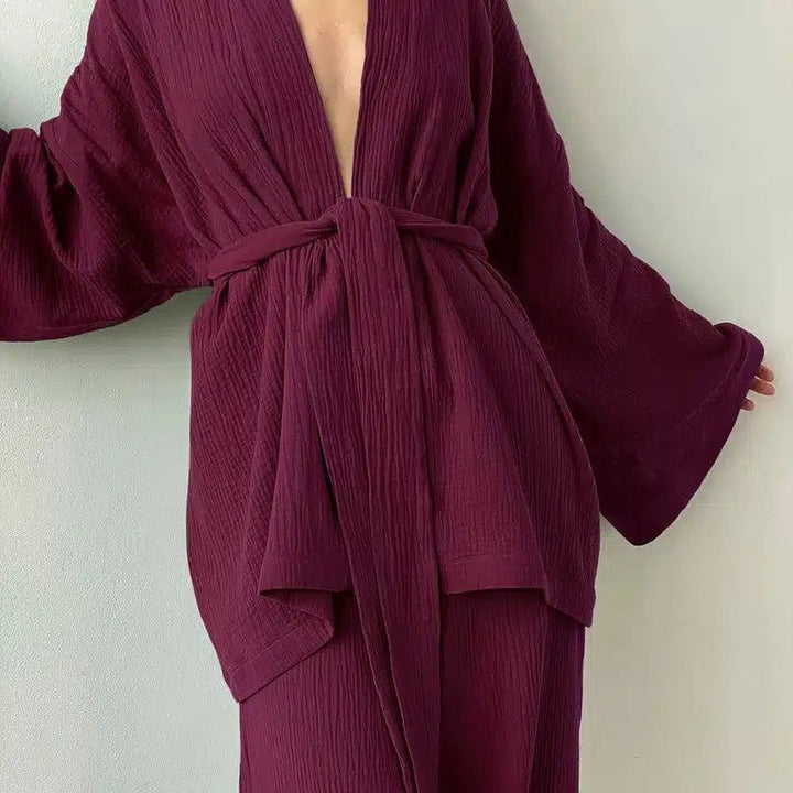 Kimono bordeaux en tissu texturé, noué à la taille. Vêtement ample avec manches évasées. Idéal pour se détendre avec style. Découvrez notre collection de kimonos uniques.