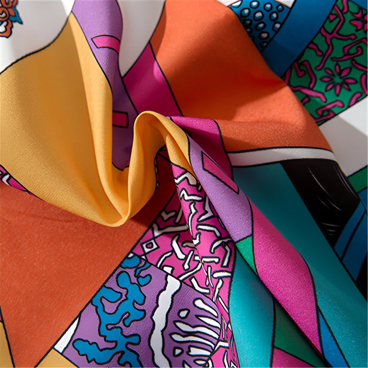 Détail d'un tissu de kimono avec motifs géométriques colorés (orange, jaune, rose, bleu). Texture de soie. Vente de kimonos en ligne.