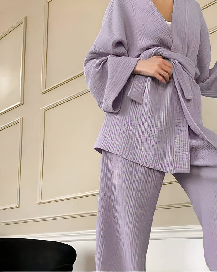 Femme portant un kimono lilas avec une ceinture assortie. Tenue confortable et élégante. Découvrez notre collection de kimonos uniques.