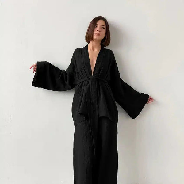Femme portant un kimono noir avec des manches amples et une ceinture, style décontracté et élégant. Kimonos de haute qualité en vente.