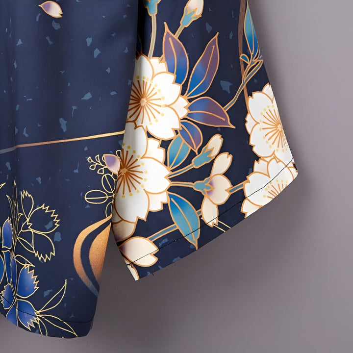 Détail d'un kimono bleu marine avec motifs floraux blancs et dorés. Gros plan sur la manche. Vêtements traditionnels japonais.
