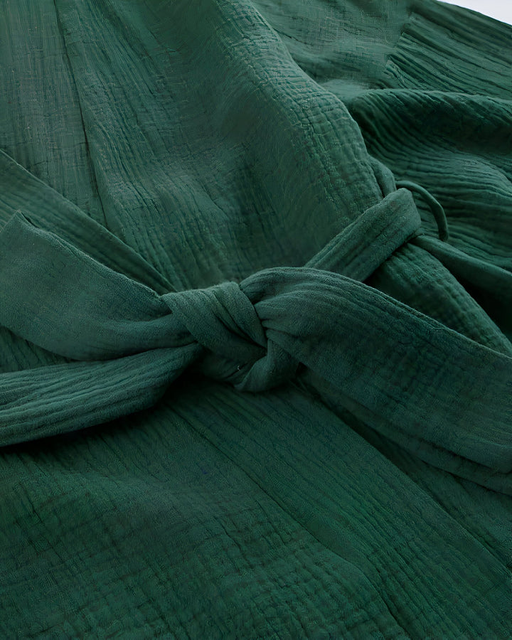 Détail d'un kimono vert émeraude en coton texturé, avec une ceinture nouée. Vêtement d'intérieur confortable et élégant, idéal pour la détente. Découvrez notre collection de kimonos.