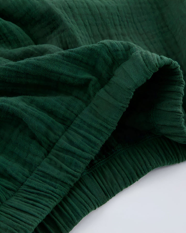 Détail de tissu gaufré vert émeraude, idéal pour kimono. Texture douce et confortable, parfaite pour une tenue élégante et décontractée. Découvrez nos kimonos de qualité supérieure !