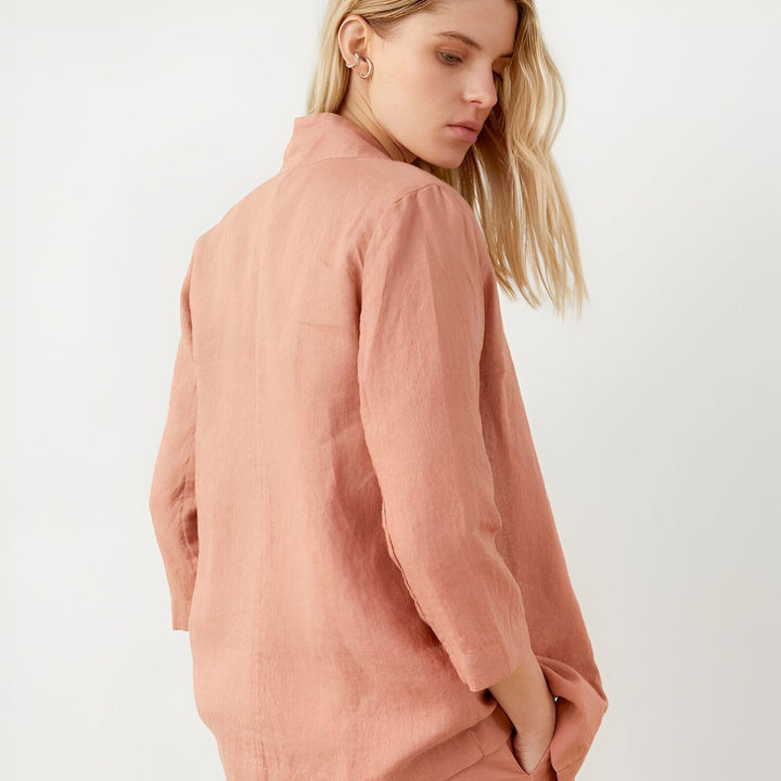 Femme portant un kimono rose en lin. Vêtement élégant et confortable, idéal pour la détente ou une occasion spéciale. Découvrez notre collection de kimonos uniques.