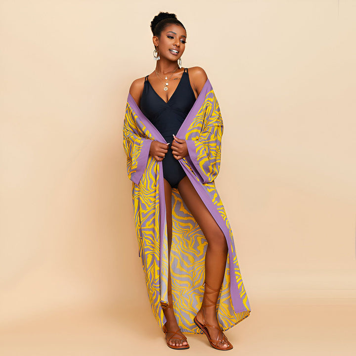 Femme noire portant un kimono jaune et violet par-dessus un maillot de bain noir. Vêtements de plage tendance. Kimonos élégants. Mode kimono.