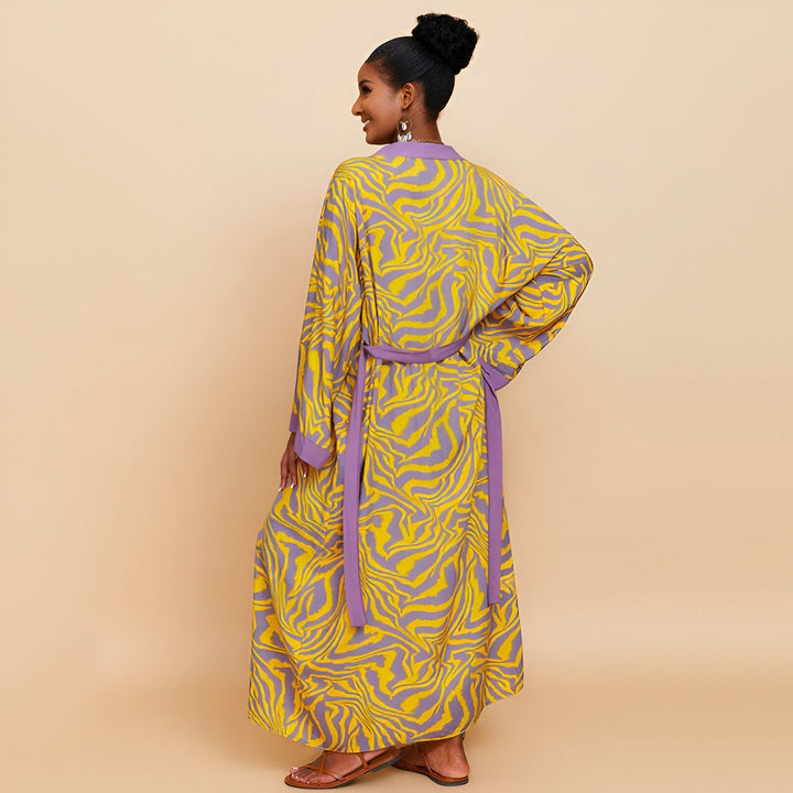Femme portant un kimono long jaune et violet avec ceinture. Vêtements de style japonais. Kimonos tendance et confortables à motifs zébrés. Découvrez notre collection de kimonos uniques.