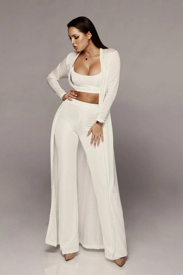 Femme élégante en ensemble kimono blanc : crop top, pantalon palazzo et veste longue. Collection de kimonos tendance.